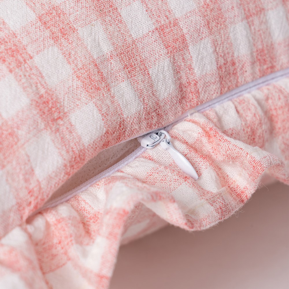 Close-up of ruffle edge detail on pink gingham cushion cover by Decor Petit