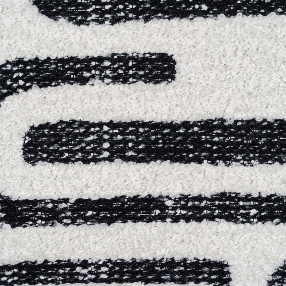 White boucle cushion cover with black abstract geometric pattern by Decor Petit